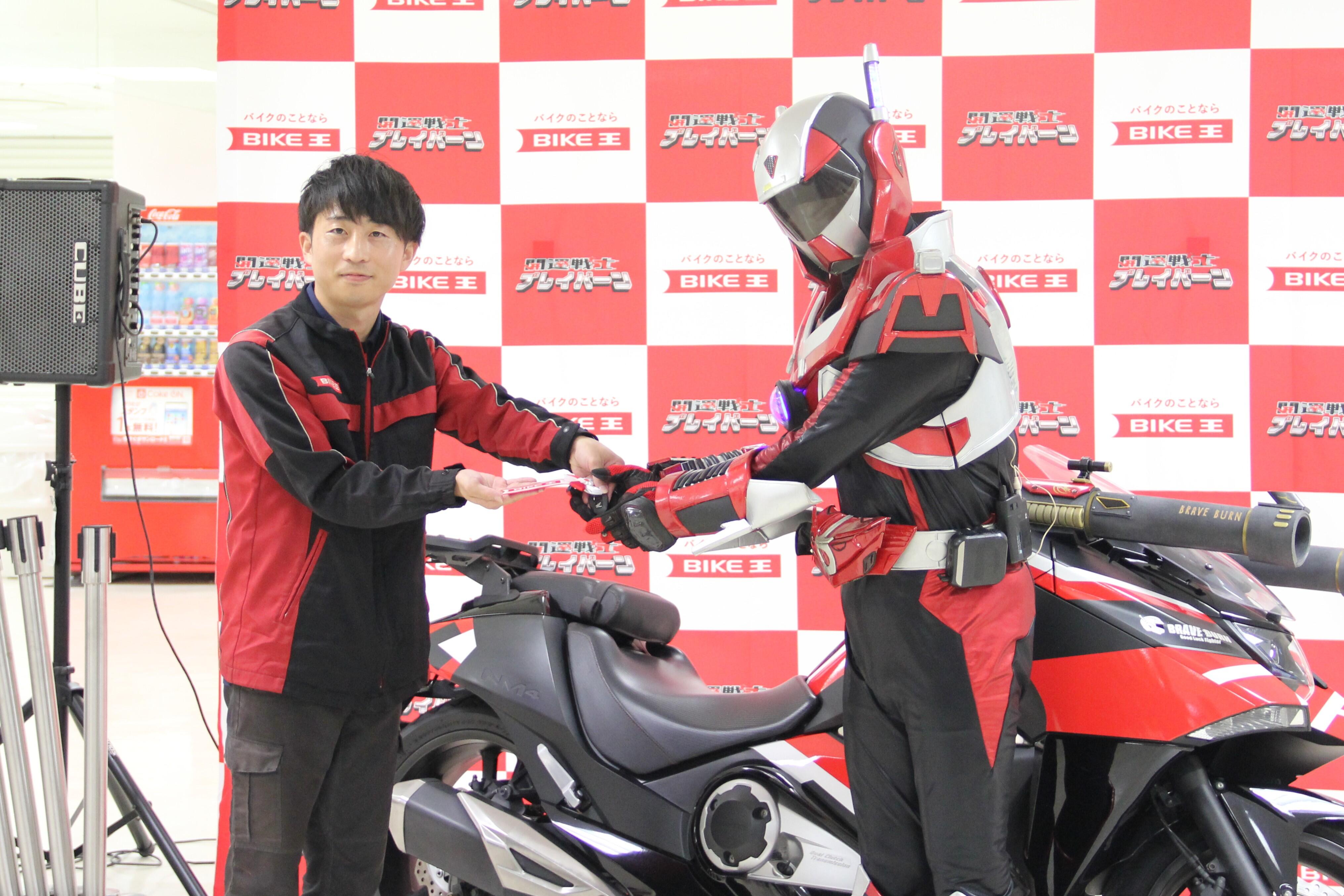 バイク王小山店岩本店長(左)からキーの譲渡